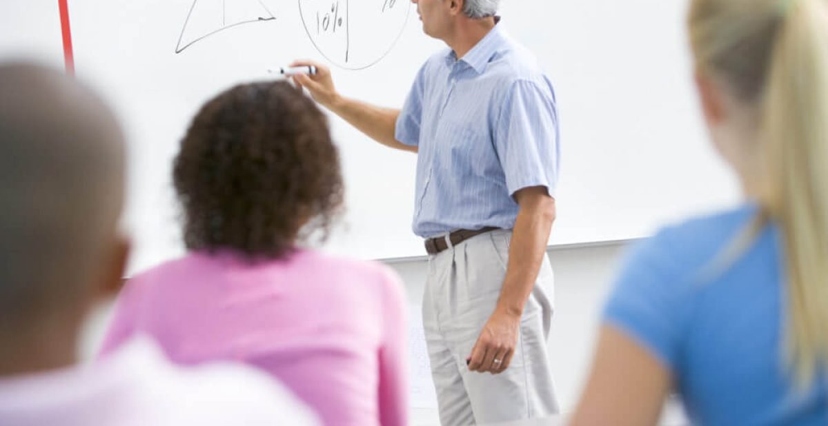 a teacher talks to school children in a high school class StrpPhABo e1522685184440